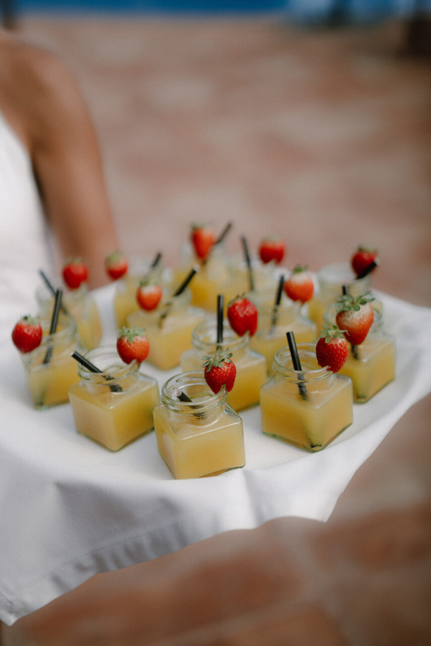 A tray with glasses garnished with strawberries.